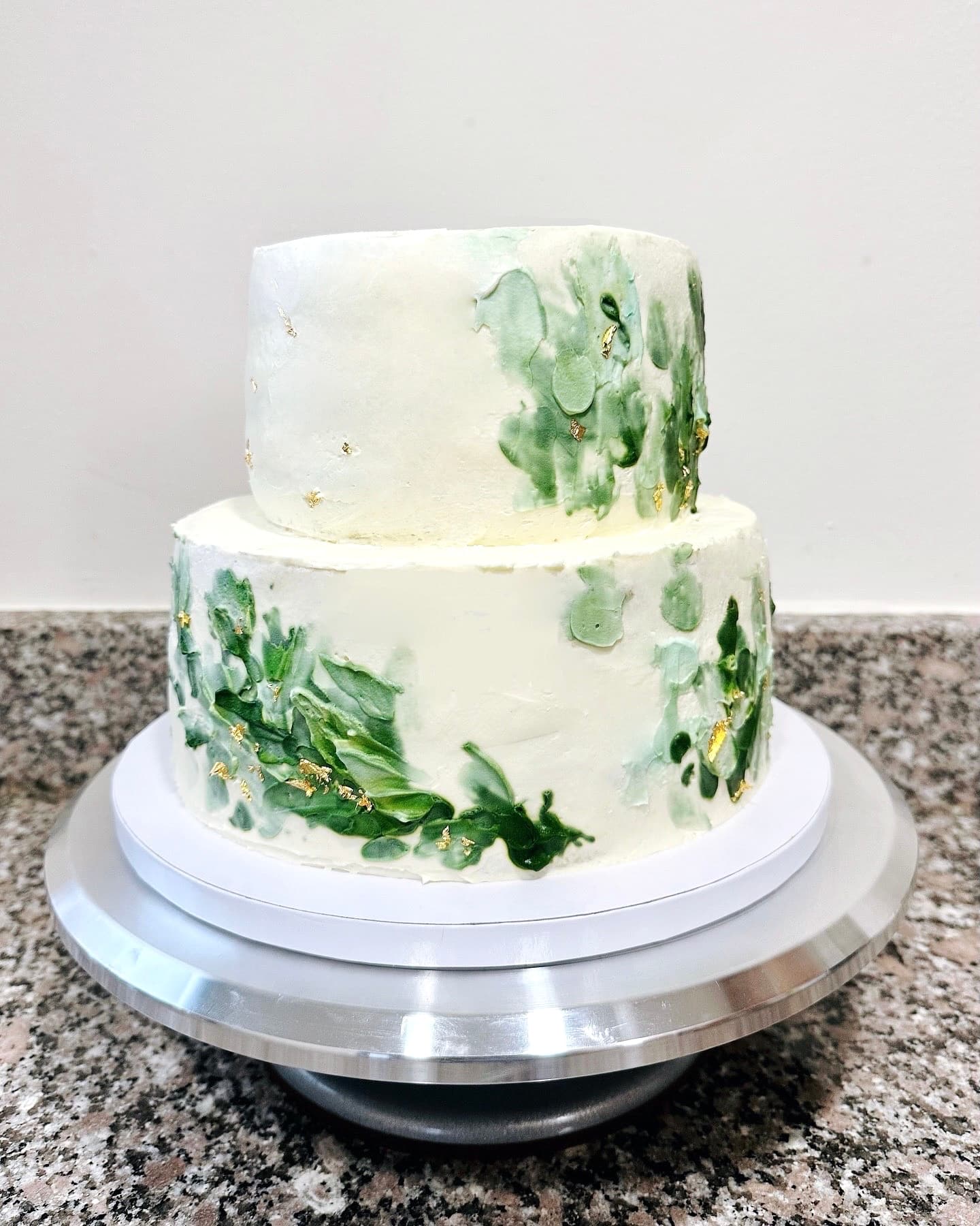 Two-tier cake with green brushstroke and gold leaf