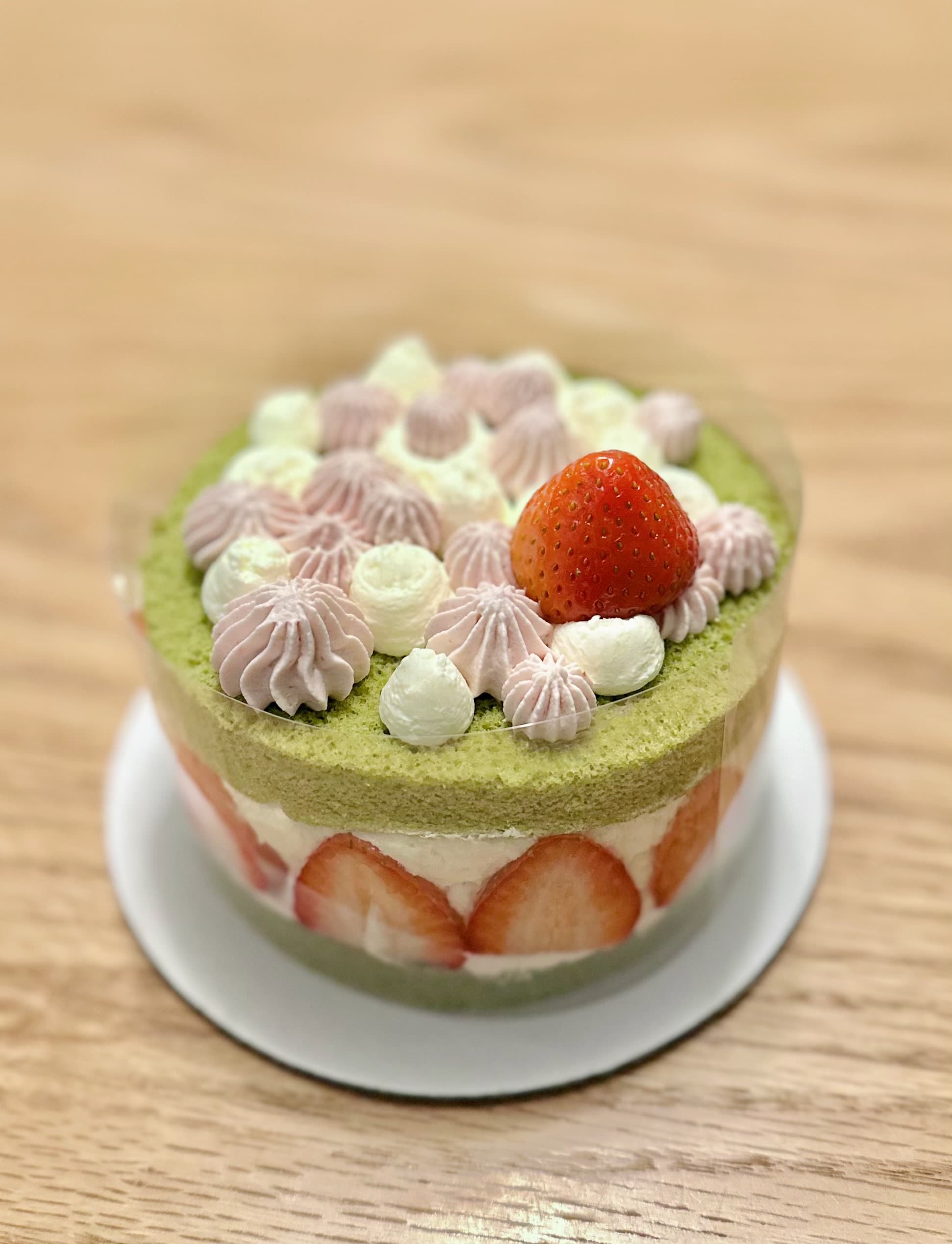Matcha strawberry cake with pink and white frosting